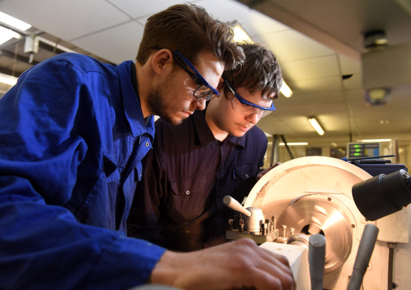 A CNC operator cutting a part on a manual CNC machine